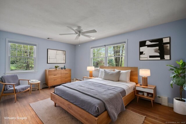 bedroom featuring wood-type flooring, visible vents, and multiple windows