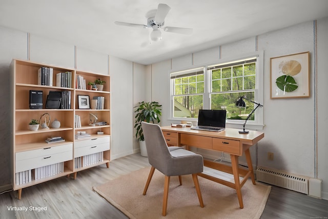 office area featuring a ceiling fan, light wood-style floors, and baseboard heating