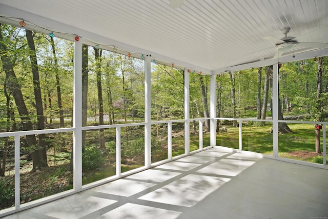 unfurnished sunroom with ceiling fan