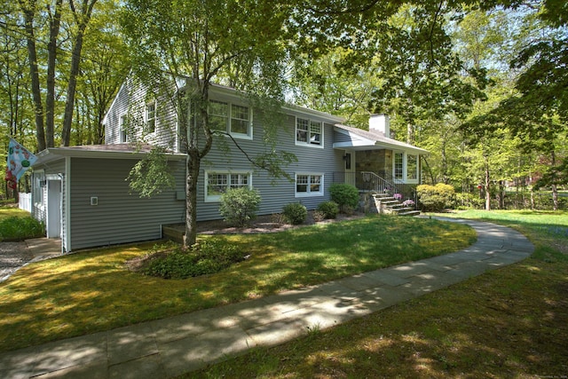split level home featuring a chimney and a front yard