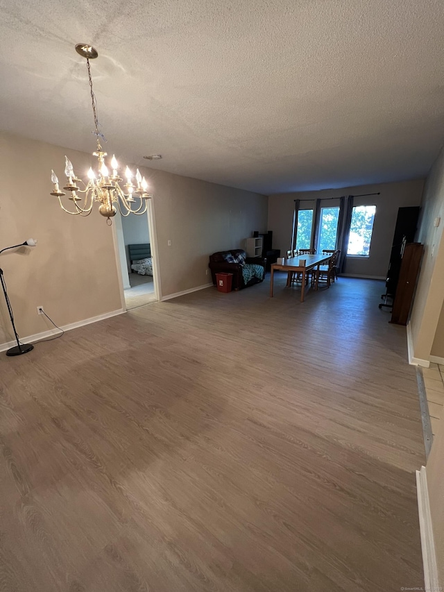 500 Prospect St Apt 1F, New Haven, CT 06511 - unfurnished dining area with a textured ceiling, wood finished floors, a chandelier, and baseboards