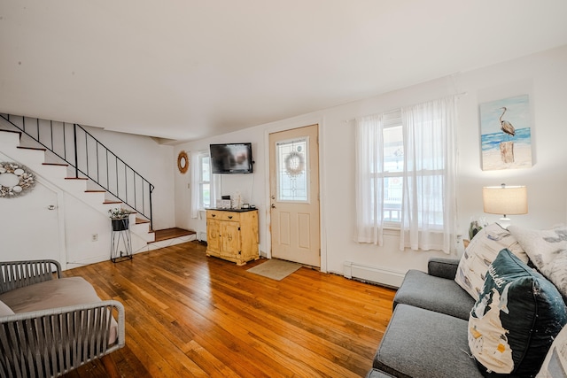 10 Sperry St, Milford, CT 06460 - living area with a baseboard heating unit, stairway, healthy amount of natural light, and wood-type flooring