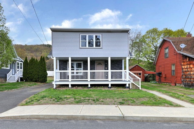 traditional-style home with a porch and a front lawn