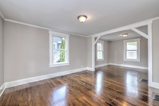 unfurnished room featuring baseboards, ornamental molding, visible vents, and dark wood-type flooring
