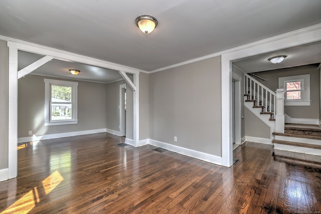 unfurnished living room featuring ornamental molding, dark wood-style flooring, stairway, and baseboards