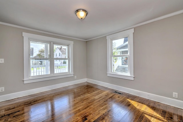 empty room featuring baseboards, dark wood-style flooring, visible vents, and plenty of natural light