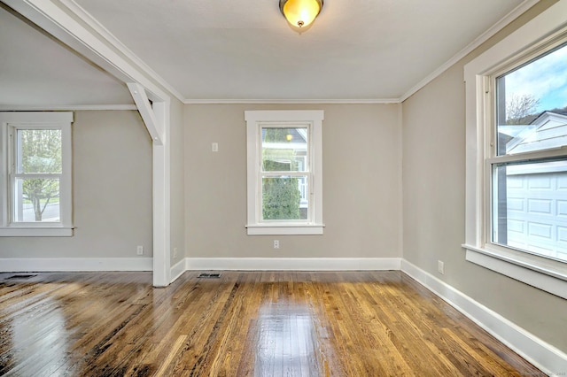 spare room featuring a wealth of natural light, hardwood / wood-style floors, and crown molding