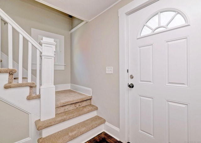 foyer entrance featuring stairway and baseboards