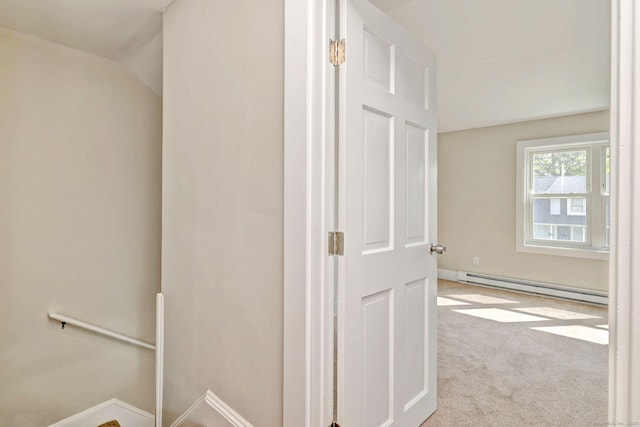 hallway with baseboards, baseboard heating, lofted ceiling, and carpet floors