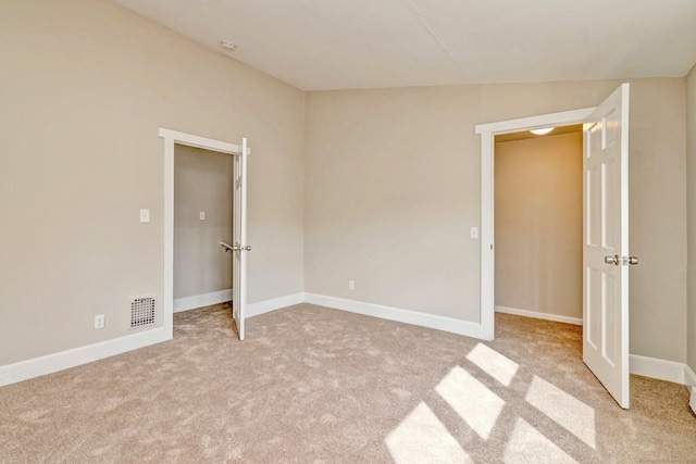 unfurnished bedroom featuring light carpet, baseboards, and visible vents