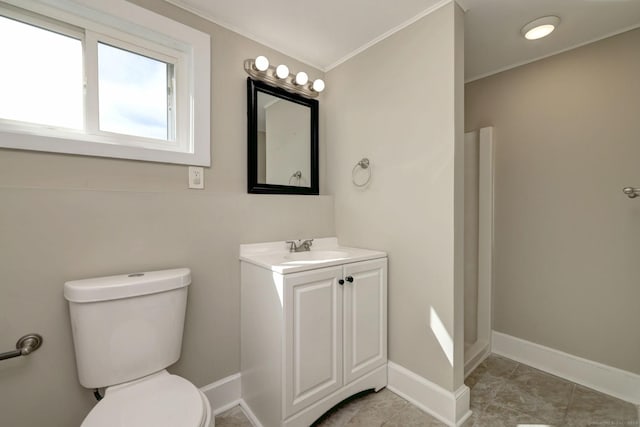 bathroom with toilet, tile patterned floors, crown molding, baseboards, and vanity