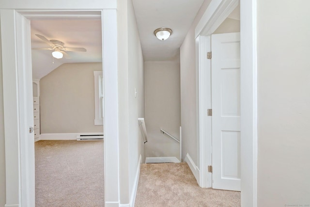 corridor featuring carpet, baseboards, a baseboard heating unit, vaulted ceiling, and an upstairs landing