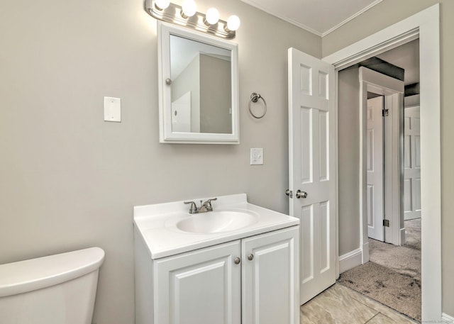 bathroom with vanity, toilet, and crown molding