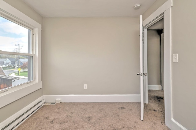 unfurnished bedroom featuring carpet flooring, baseboards, and baseboard heating