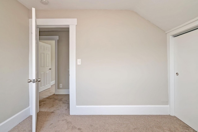 interior space with carpet, a closet, baseboards, and lofted ceiling
