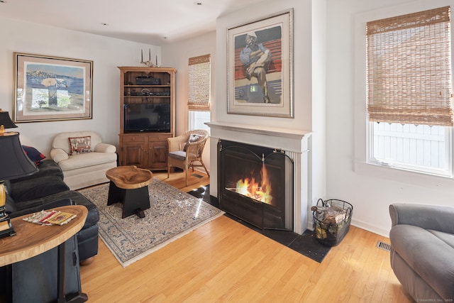 43 Pine Point Rd, Norwalk, CT 06853 - living room featuring a wealth of natural light, visible vents, wood finished floors, and a fireplace with flush hearth