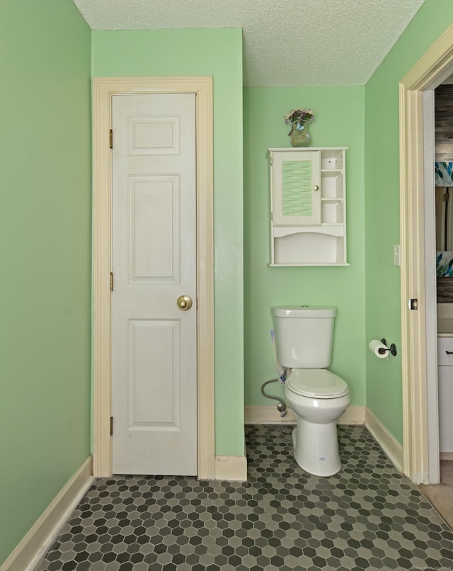 75 Redwood Dr Unit 609, East Haven, CT 06513 - bathroom featuring baseboards, toilet, and a textured ceiling