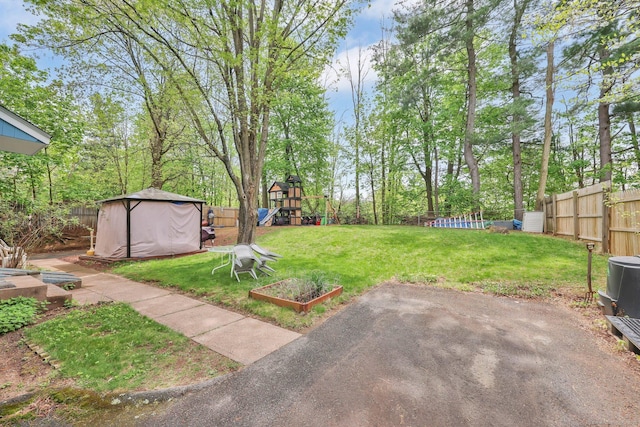view of yard with a fenced backyard, a playground, and a patio