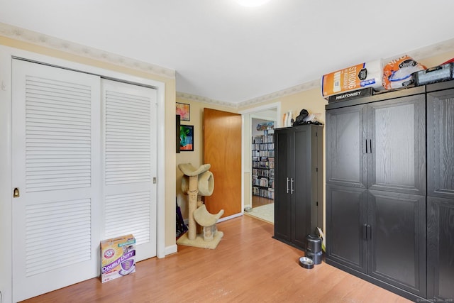 bedroom featuring a closet, wood finished floors, and baseboards