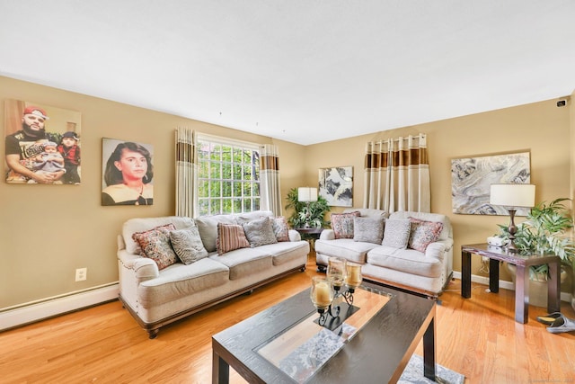 living area with baseboards, baseboard heating, and light wood finished floors