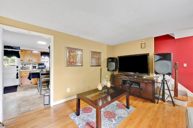 living room featuring baseboards and light wood-type flooring