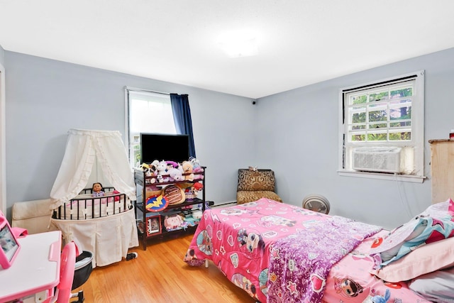 bedroom featuring cooling unit and wood finished floors