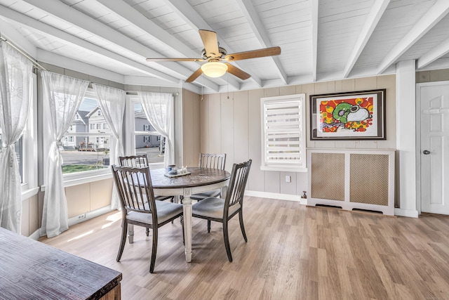 dining area featuring light wood-style floors, baseboards, ceiling fan, and beam ceiling