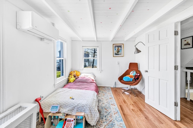 bedroom with beam ceiling, an AC wall unit, and light wood-type flooring