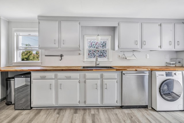 kitchen featuring washer / dryer, dishwasher, butcher block countertops, and a sink