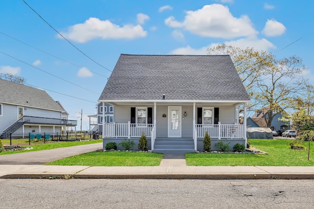 view of front of house featuring a porch, a shingled roof, and asphalt driveway