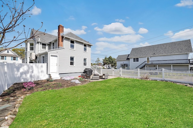 back of house with a chimney, an outdoor living space, and a patio area