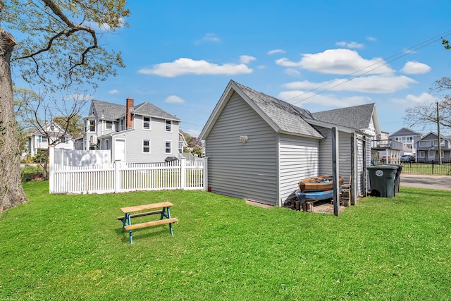 back of property with roof with shingles and a residential view
