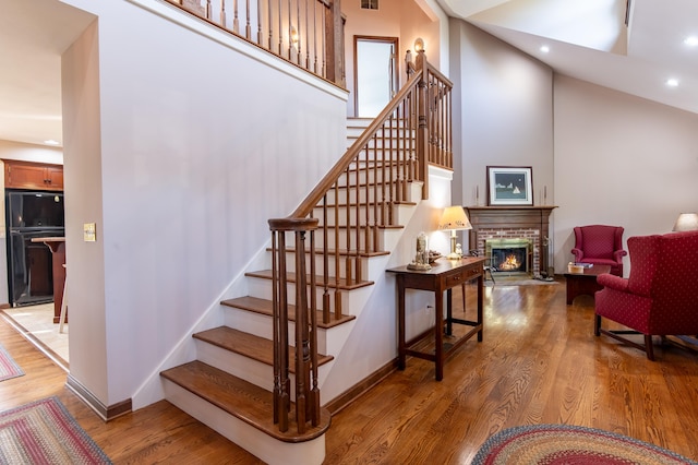23 Hefflon Farm Rd, Old Lyme, CT 06371 - stairs featuring wood finished floors, recessed lighting, a brick fireplace, baseboards, and high vaulted ceiling
