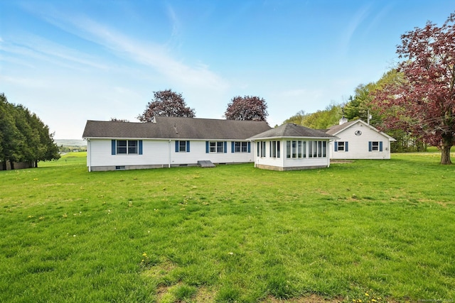 rear view of property with a sunroom and a yard