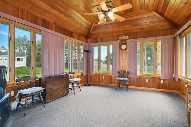sunroom / solarium featuring carpet floors, vaulted ceiling, wood walls, wood ceiling, and baseboards
