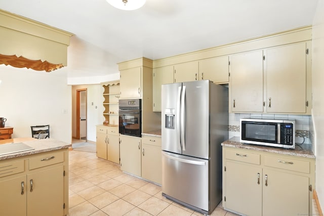 kitchen with stainless steel appliances, cream cabinetry, light countertops, light tile patterned floors, and backsplash