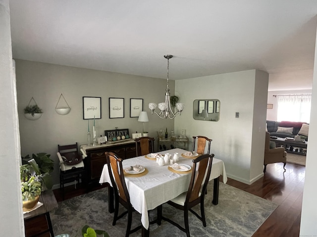 dining room featuring baseboards, dark wood-style flooring, and a notable chandelier