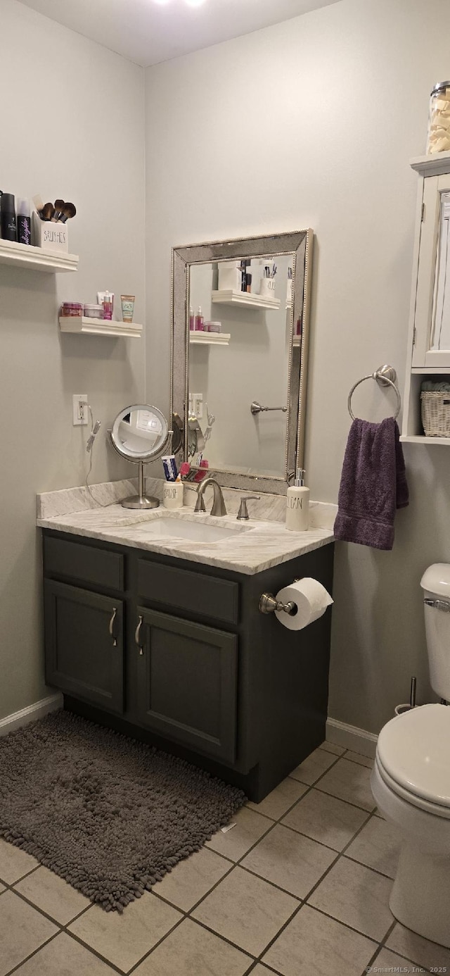 bathroom featuring tile patterned floors, toilet, baseboards, and vanity