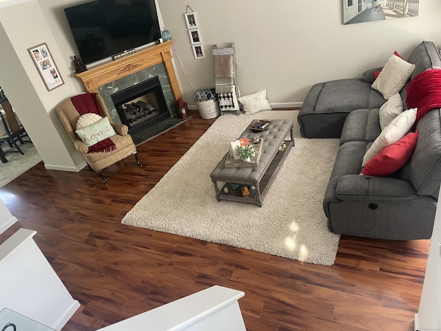 living room featuring wood finished floors, baseboards, and a high end fireplace