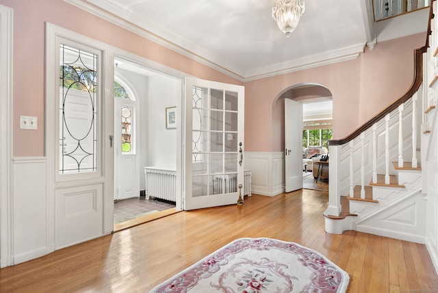 44 Walbridge Rd, West Hartford, CT 06119 - foyer entrance featuring arched walkways, hardwood / wood-style floors, ornamental molding, a decorative wall, and wainscoting