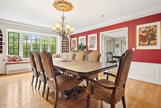 44 Walbridge Rd, West Hartford, CT 06119 - dining room with crown molding, a chandelier, wainscoting, light wood-style flooring, and a decorative wall