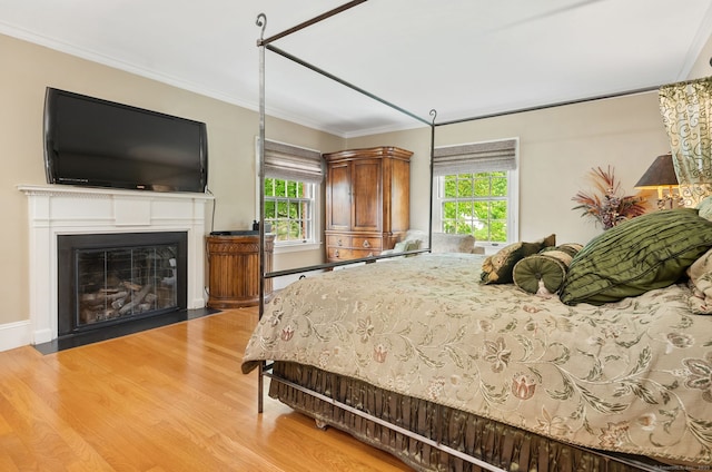 44 Walbridge Rd, West Hartford, CT 06119 - bedroom featuring wood finished floors, multiple windows, a fireplace with flush hearth, and crown molding
