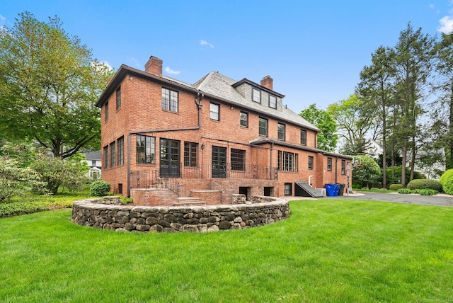 44 Walbridge Rd, West Hartford, CT 06119 - rear view of house with a chimney, brick siding, and a lawn