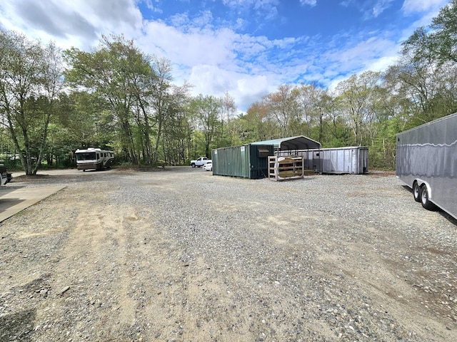 69 Elmdale Rd, Canterbury, CT 06331 - view of yard with a detached carport, gravel driveway, an outdoor structure, and view of scattered trees