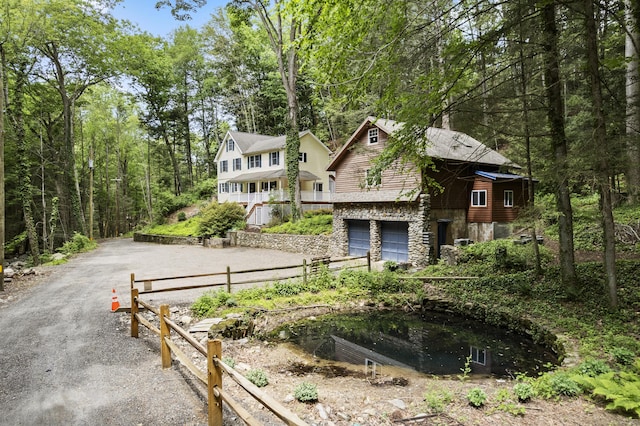 18 Brookside Trl, Monroe, CT 06468 - view of front of property featuring stone siding, driveway, and a garage