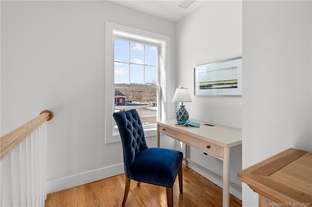 office area with baseboards, visible vents, and wood finished floors