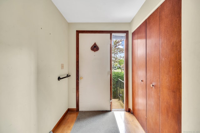 foyer entrance featuring light wood finished floors and baseboards