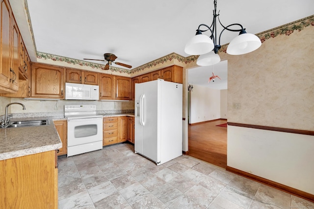 kitchen featuring a sink, white appliances, light countertops, a ceiling fan, and baseboards