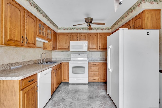 kitchen featuring a sink, brown cabinetry, ceiling fan, white appliances, and light countertops