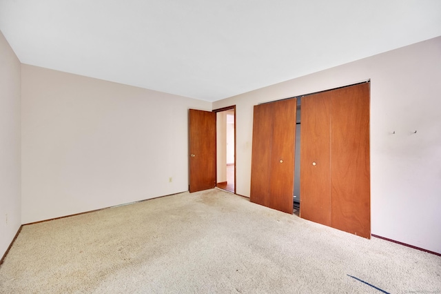 unfurnished bedroom with baseboards, a closet, and carpet